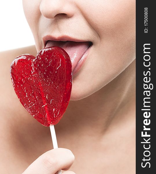 Closeup shot of girl with red heart lolipop isolated on white