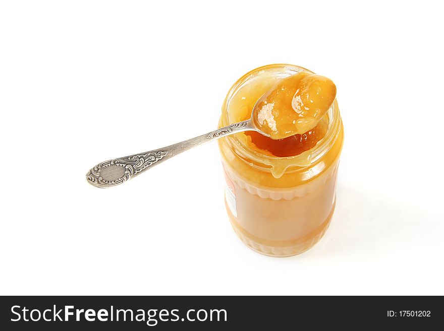 Honey in the jar with spoon isolated on white background