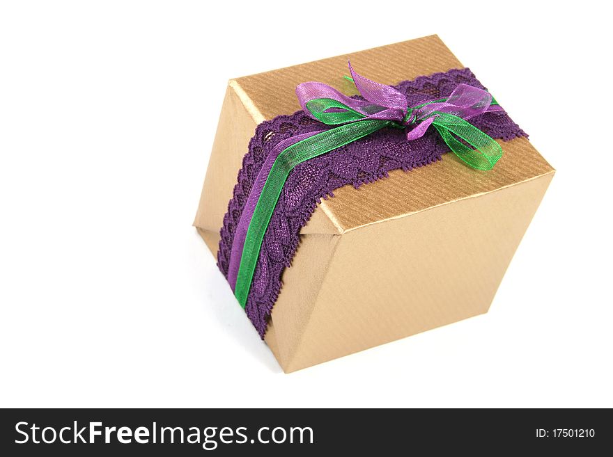 Gift box wrapped in golden paper and tied with purple lace