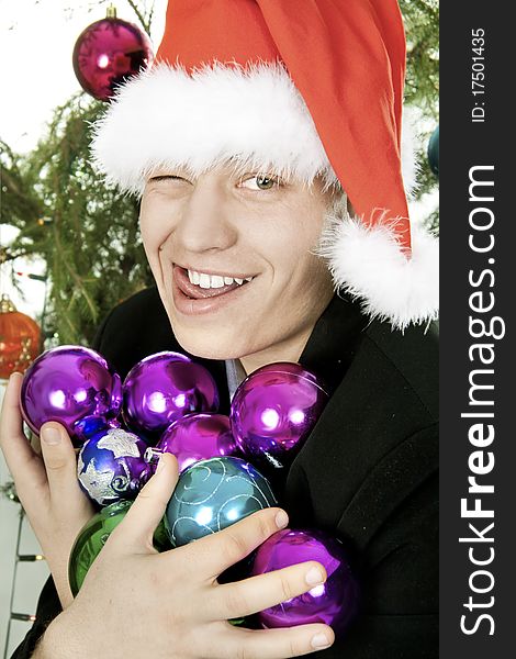 Young man holds an armful of fur-tree toys and puts out the tongue