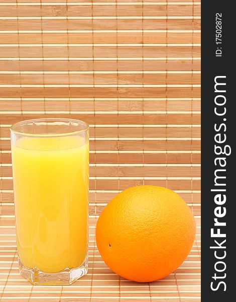 Orange juice in a glass and an orange