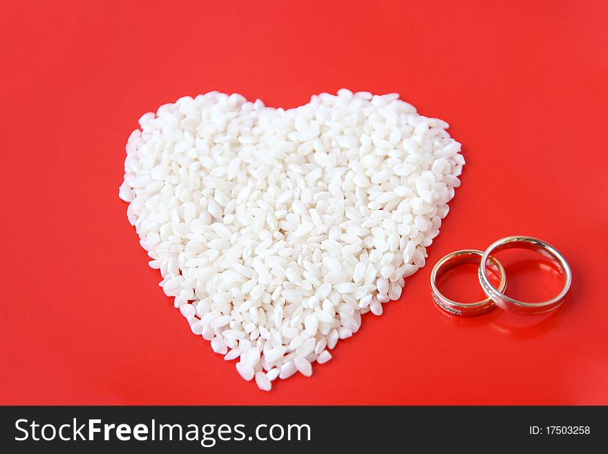 White heart on red background with two wedding rings. White heart on red background with two wedding rings