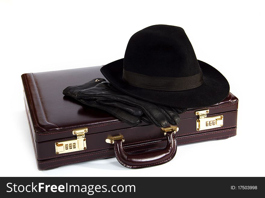 Suitcase with laying from above a hat and gloves on a white background