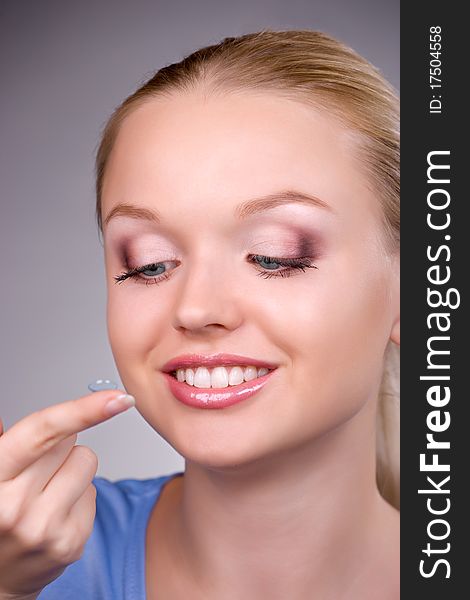 Contact lens on finger of young woman, close-up portrait