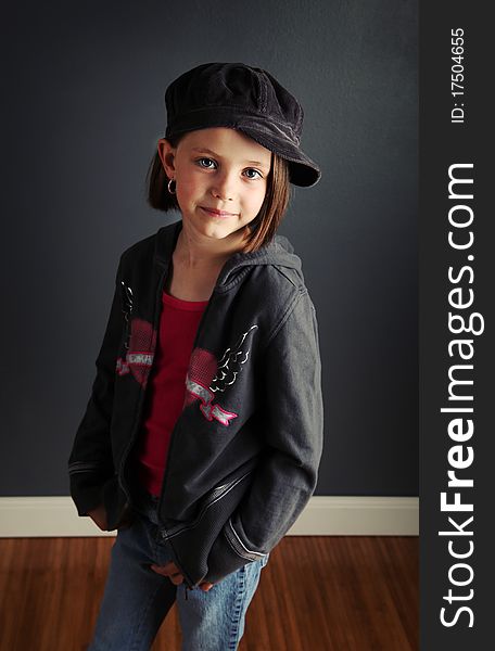 Beautiful young female child wearing a newsboy cap and ripped jeans. Beautiful young female child wearing a newsboy cap and ripped jeans