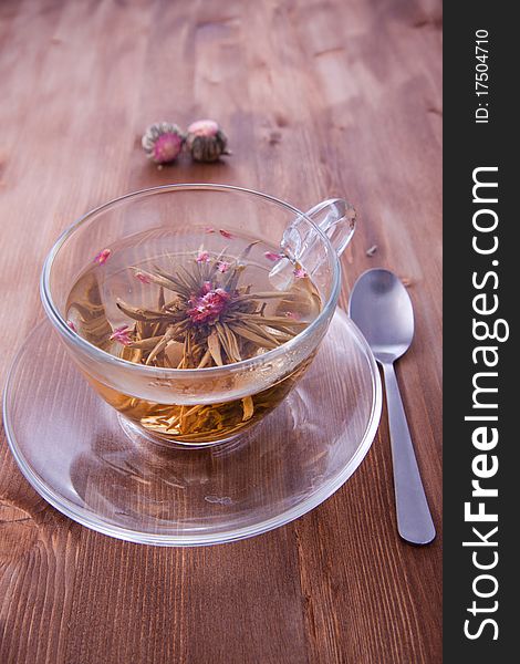 Transparent cup of a green tea with the teaspoon on the wooden table. Transparent cup of a green tea with the teaspoon on the wooden table