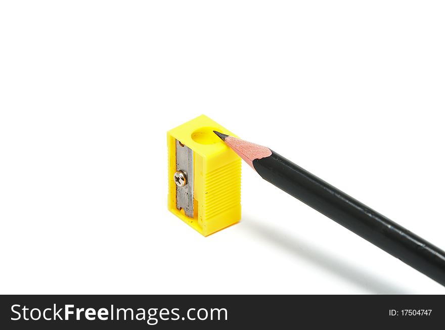 Yellow sharpener and black pencil on the white background