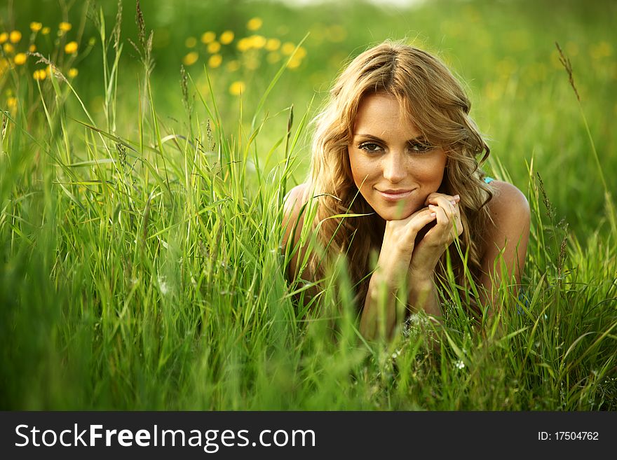 Blonde lays on green grass. Blonde lays on green grass