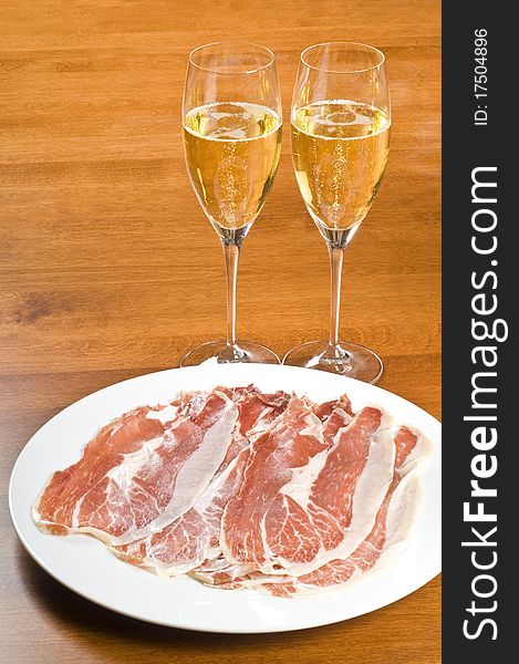 Two glasses of Champagne and plateful of Iberico ham. Two glasses of Champagne and plateful of Iberico ham.