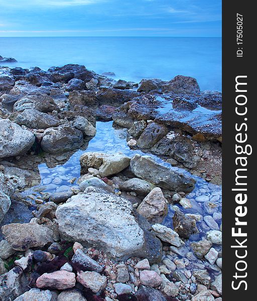 Stone and reflections in water during sundown