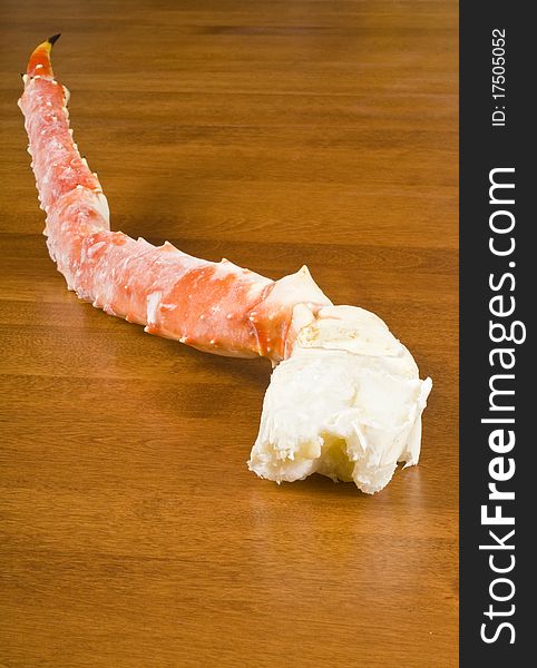 Pre-cooked frozen Alaskan King Crab leg on a table.