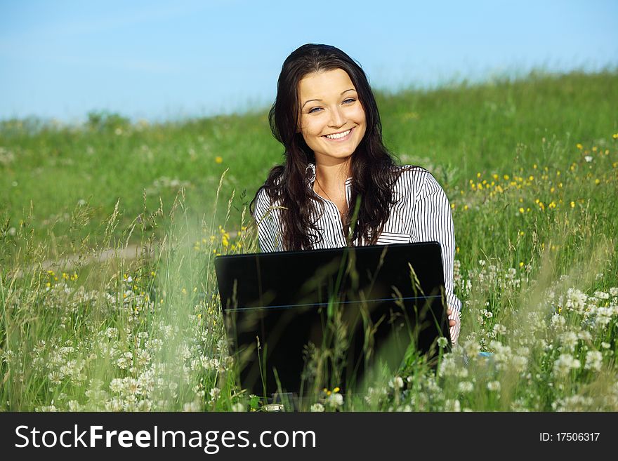 Woman on green field work on laptop. Woman on green field work on laptop
