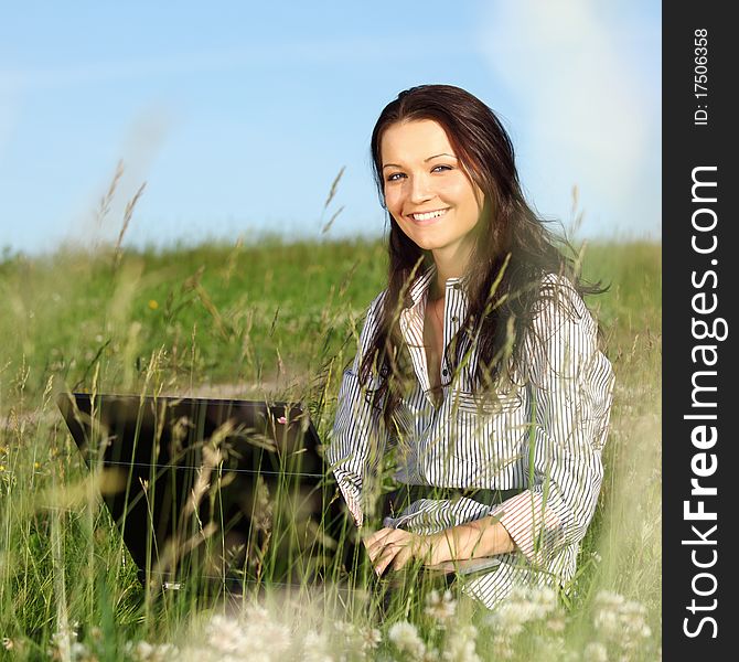 Woman on green field work on laptop. Woman on green field work on laptop