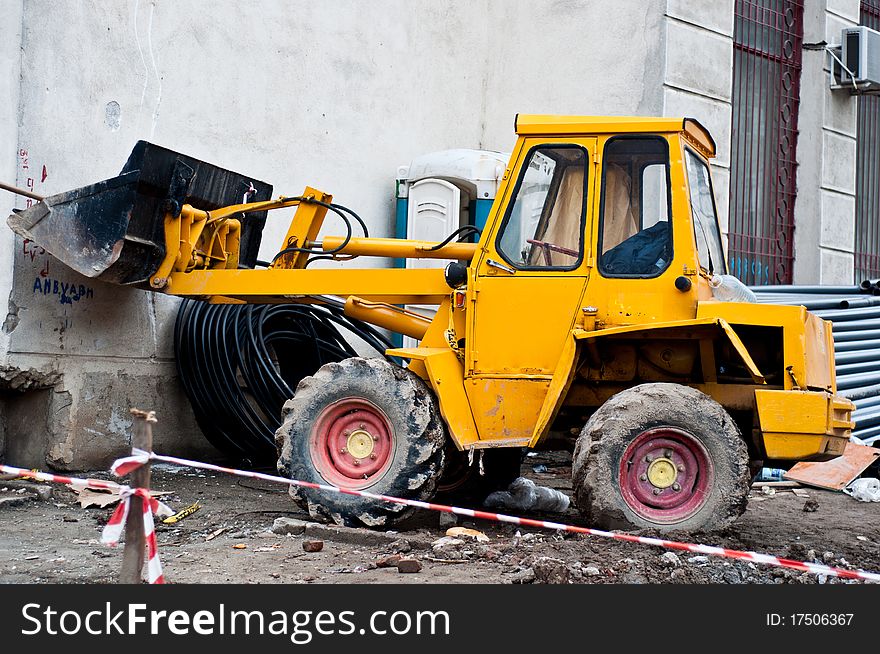 Yellow bulodozer on a construction site, with dirty wheels. Yellow bulodozer on a construction site, with dirty wheels