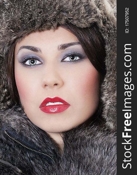 Portrait of young beautiful woman in a fur coat and hat