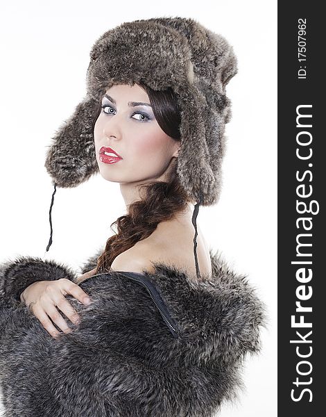 Portrait of young beautiful woman in a fur coat and hat