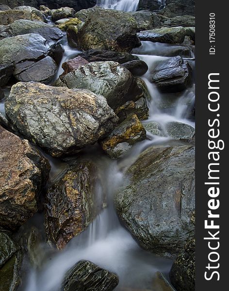 Bottom of the waterfall at Backways Cove on the north Cornwall coast near Tintagel, the stream flow over a diverse range of boulders. Bottom of the waterfall at Backways Cove on the north Cornwall coast near Tintagel, the stream flow over a diverse range of boulders