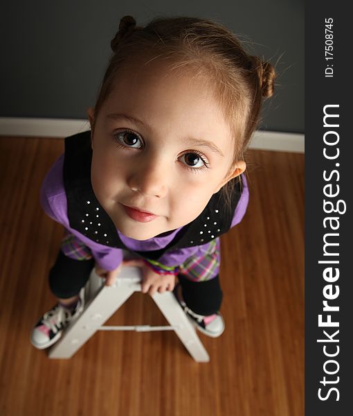 Young girl sitting on a ladder, shot from above. Young girl sitting on a ladder, shot from above