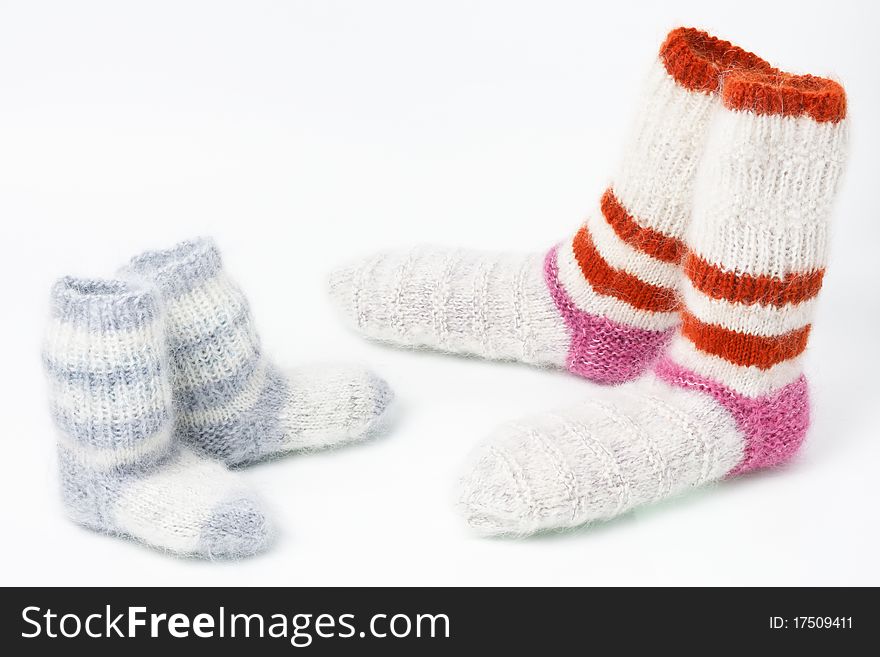 Pairs of strip multicolored woolen mohair man`s and child`s socks standing one against another on white background. Pairs of strip multicolored woolen mohair man`s and child`s socks standing one against another on white background