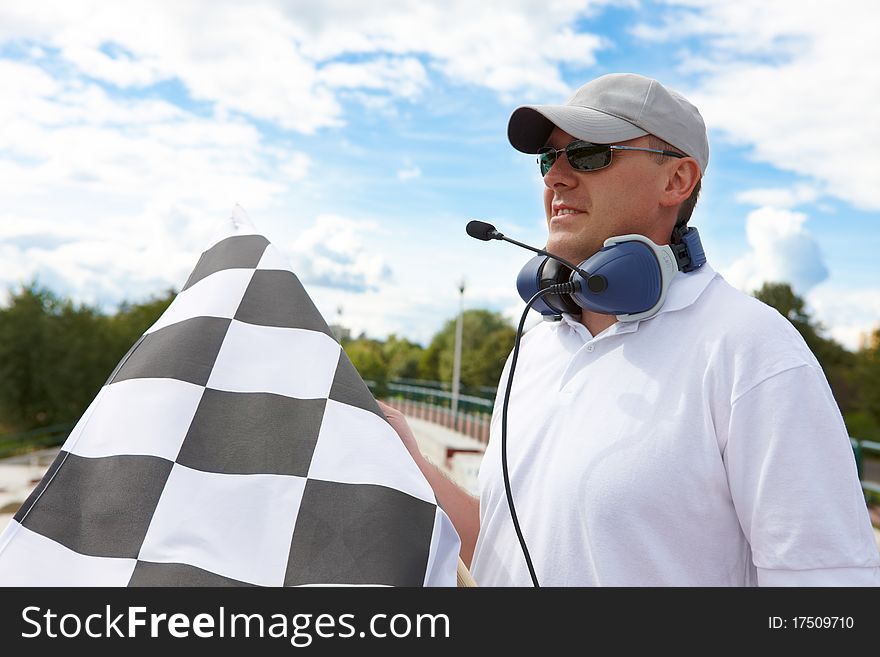 Flagman with checkered flag meaning that winner has just crossed the finish line.