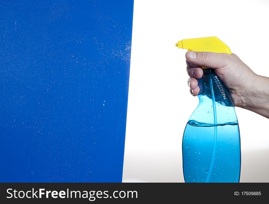 Hahd holding bottle of cleaning solution on the blue background