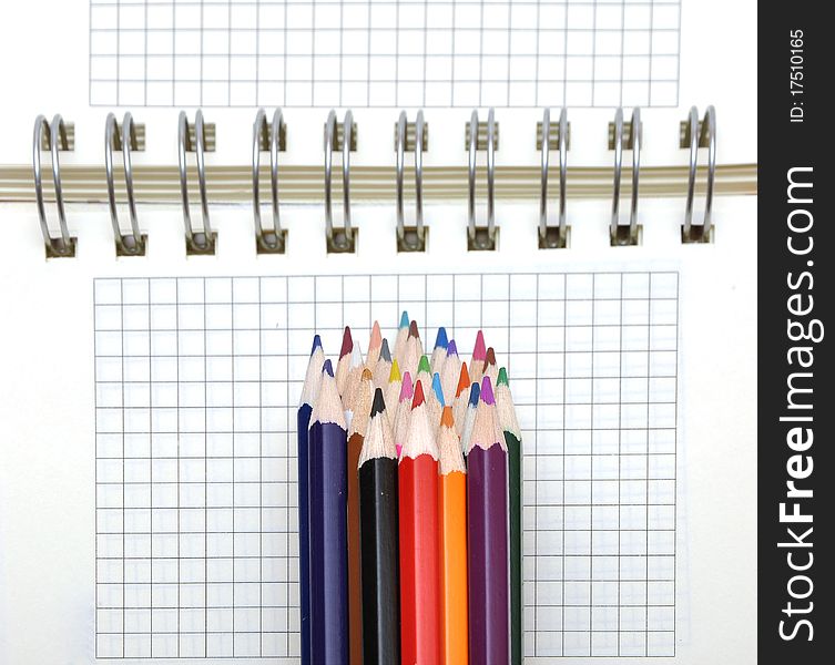 Blank notebook and color pencils isolated on white