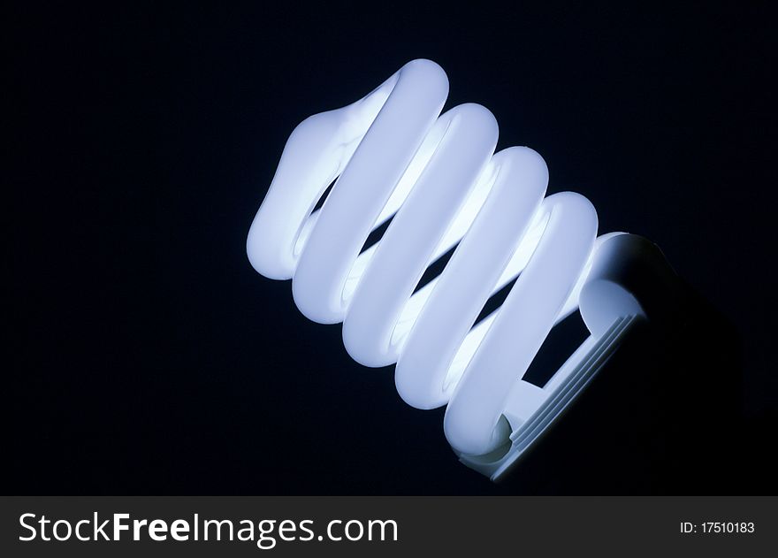 Spiral fluorescent lamp isolated on black background