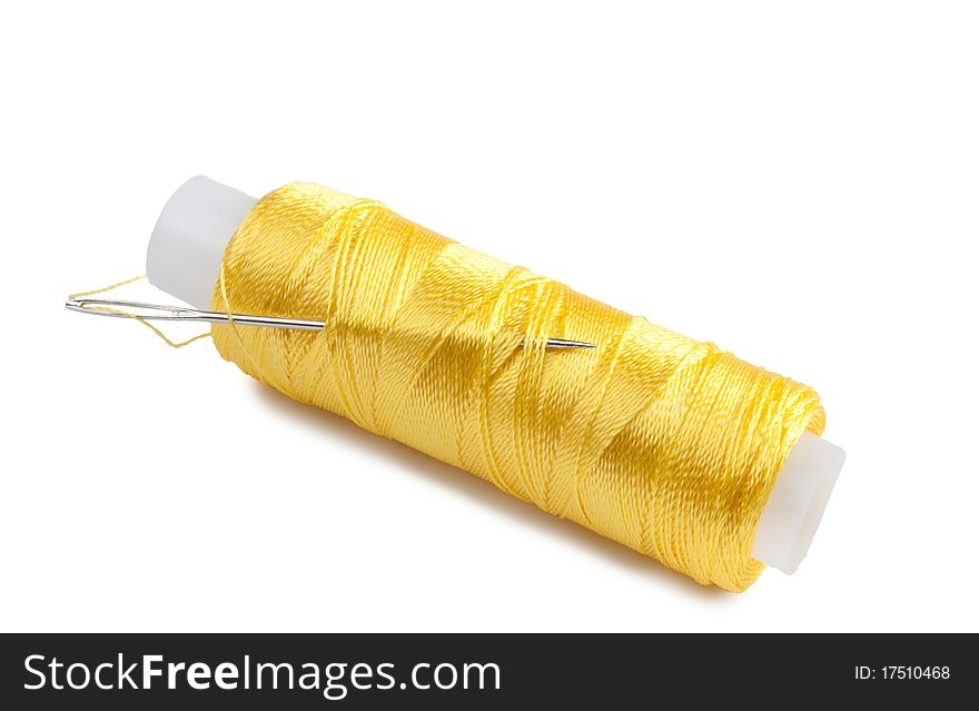 Yellow spool with needle on a white background