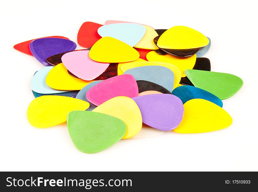 A stack of various color guitar picks on white