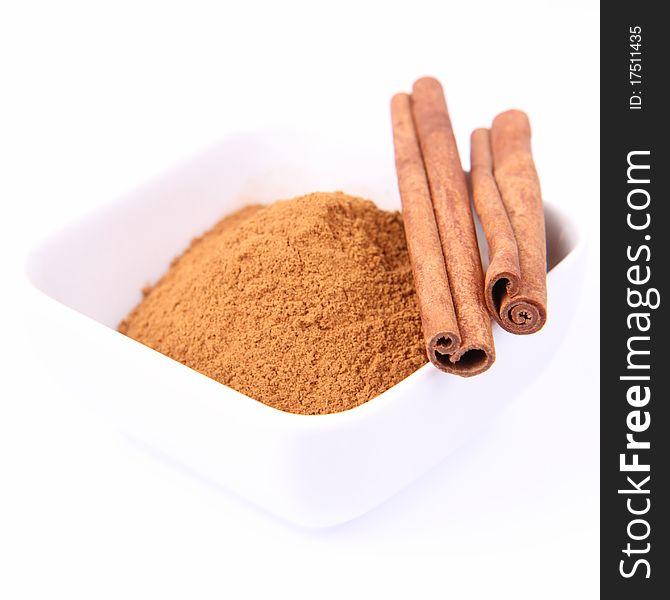 Cinnamon sticks and ground cinnamon on white background