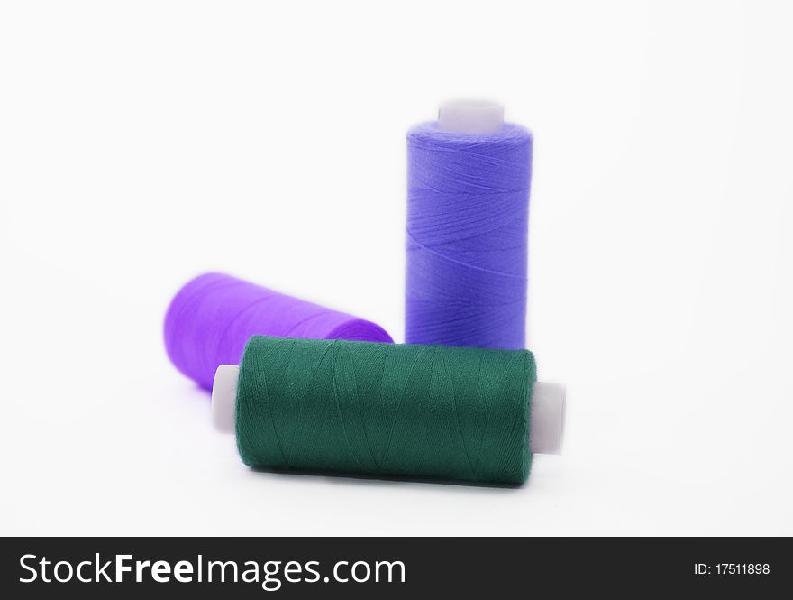 Three bobbins of colour threads isolated on white background. Three bobbins of colour threads isolated on white background