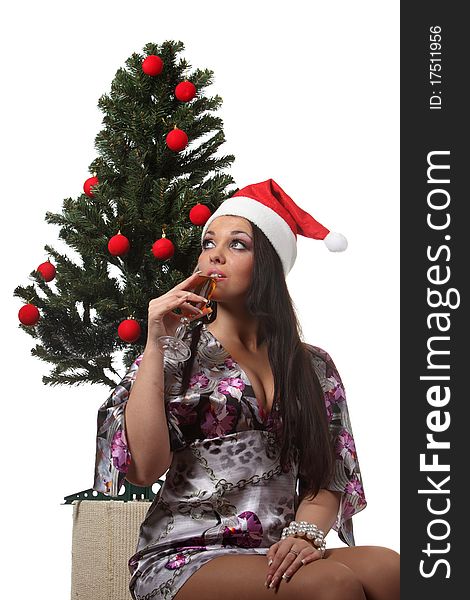 Woman drink a wine in front of a christmas tree