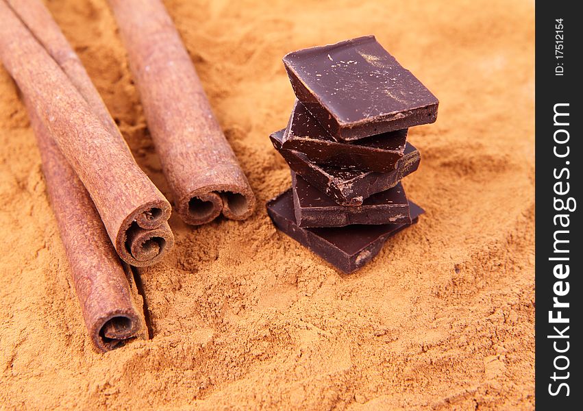 Chocolate pieces with cinnamon sticks and ground cinnamon. Chocolate pieces with cinnamon sticks and ground cinnamon