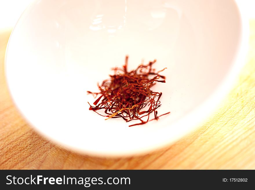 Strands of saffron in a white bowl. Strands of saffron in a white bowl