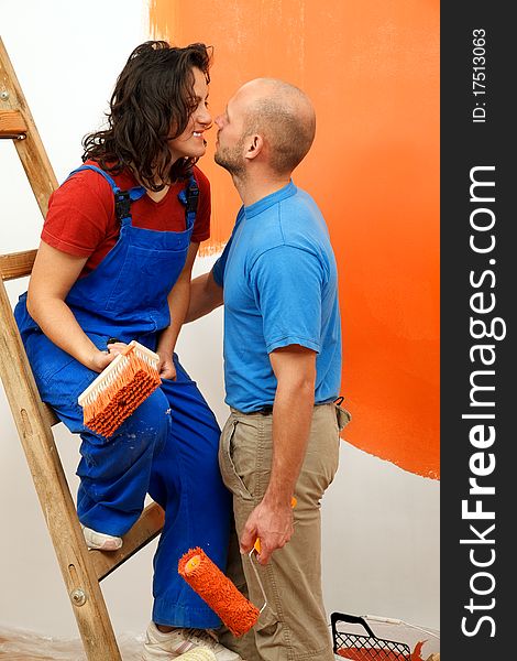 Romantic moments of a young pair during the wall painting. Romantic moments of a young pair during the wall painting