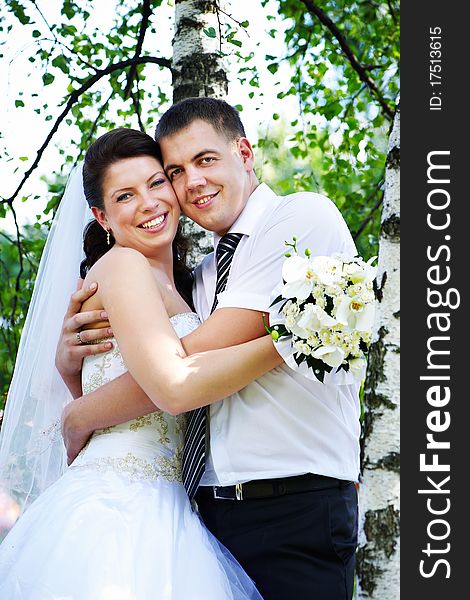 Happy bride and groom at the birches in the park