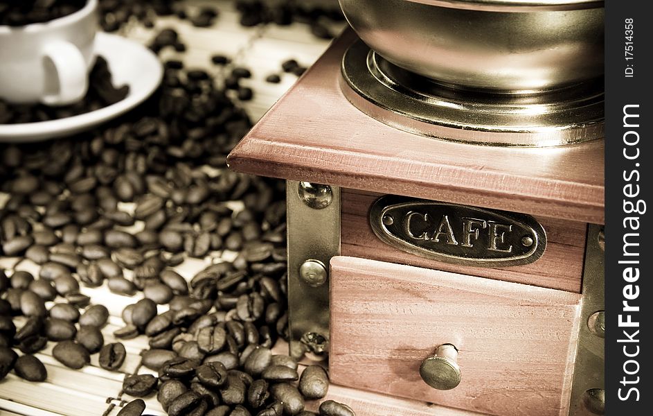Coffee beans, cup and grinder on sacking