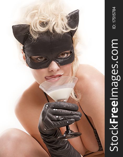 Portrait of the blond model wearing black cat, licking - drinking milk from the martini glass. Portrait of the blond model wearing black cat, licking - drinking milk from the martini glass