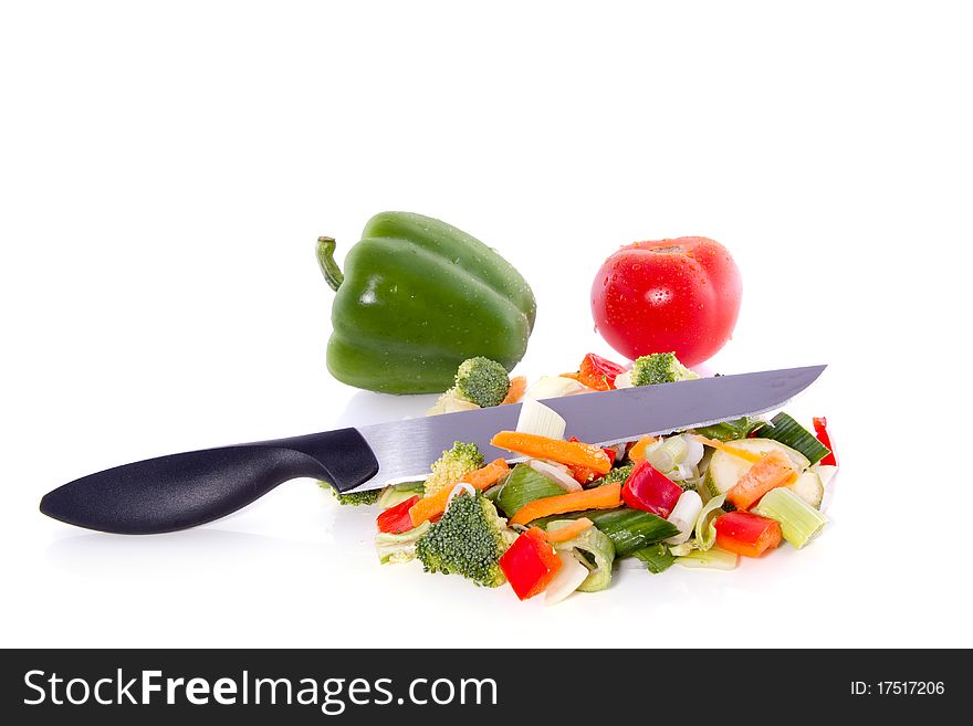 Cut vegetables with a knife on top  isolated over white