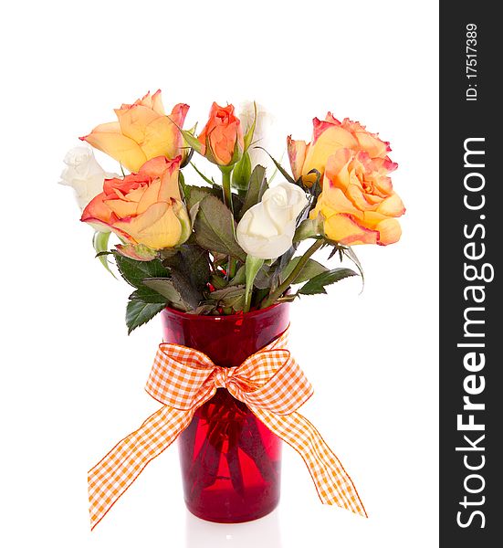 Orange and white roses in a red glass vase isolated over white