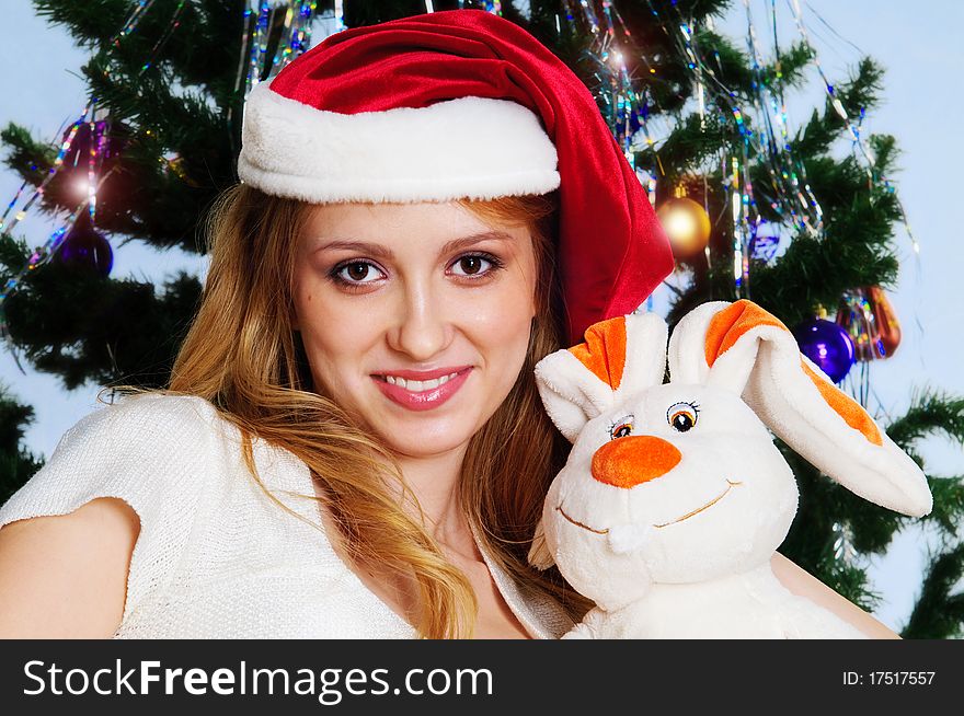 Woman posing in a studio against a Christmas tree with a rabbit (symbol 2011). Woman posing in a studio against a Christmas tree with a rabbit (symbol 2011)
