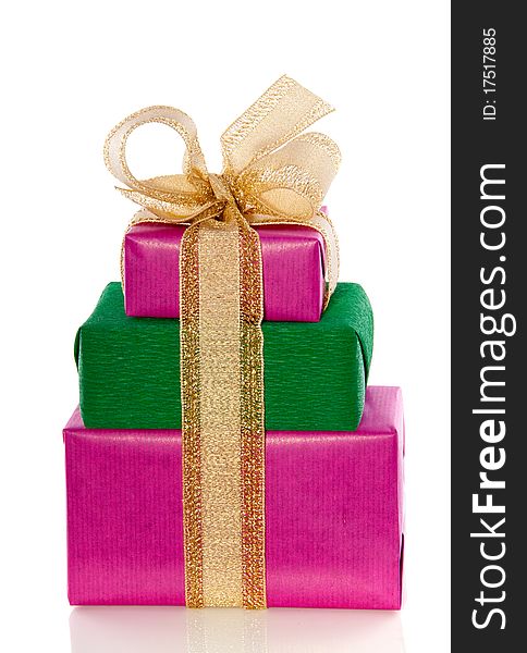 A pile of pink green gifts with a golden ribbon isolated over white