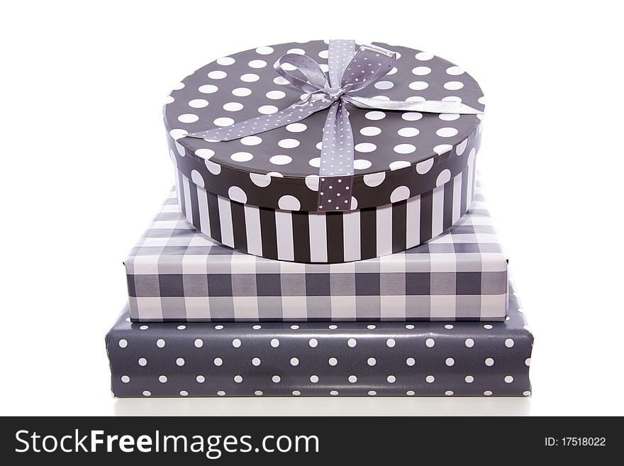 A pile grey white dotted and checkered gifts with ribbons isolated on white background. A pile grey white dotted and checkered gifts with ribbons isolated on white background