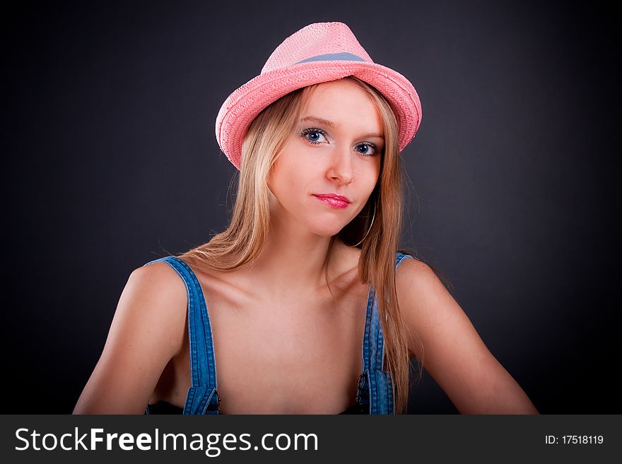 Pretty girl in pink hat and jeans overalls