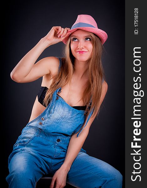 Pretty girl in pink hat and jeans overalls