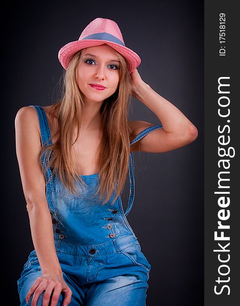 Pretty girl in pink hat and jeans overalls