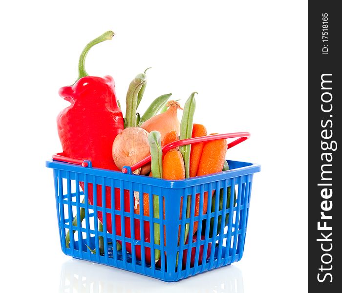 Fresh vegetables in a plastic shopping basket isolated over white