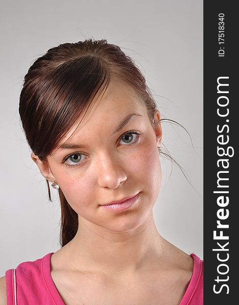 Girl with calm expression against grey background. Close-up taken in the studio. Girl with calm expression against grey background. Close-up taken in the studio