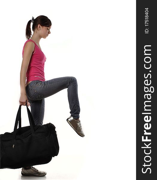 Slim girl striding with a big black sports bag. Motion blur is slightly present. Studio shot against white background. Slim girl striding with a big black sports bag. Motion blur is slightly present. Studio shot against white background