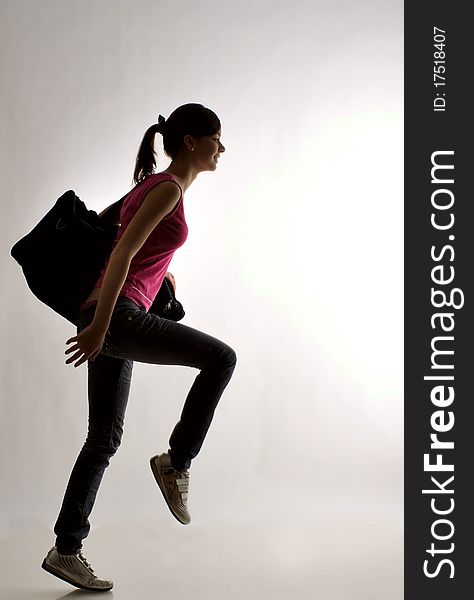 Smiling girl striding against gray background. Smiling girl striding against gray background